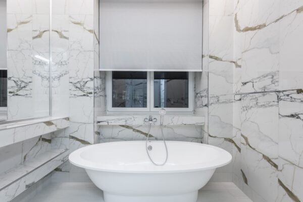 Salle de bain rénovée avec baignoire îlot et revêtement marbre, Paris